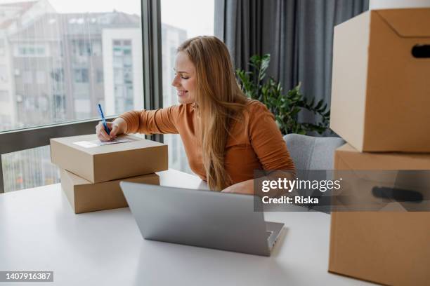 young entrepreneur preparing a package she is going to send - parcel laptop stock pictures, royalty-free photos & images