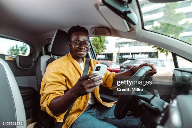 using smart phone and driving a car - mobile app car stock pictures, royalty-free photos & images