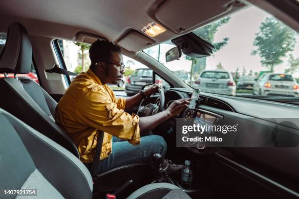 uber driver checks his smart phone to see if he got to the address requested by the client - taxi driver 個照片及圖片檔