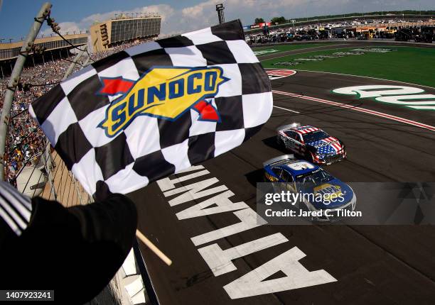 Chase Elliott, driver of the NAPA Auto Parts Chevrolet, takes the checkered flag to win the NASCAR Cup Series Quaker State 400 at Atlanta Motor...