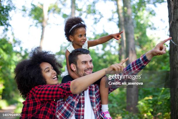 glückliche familie zu fuß entlang der pfad im wald - baby bag stock-fotos und bilder