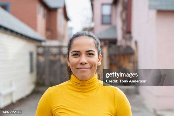 portrait of woman in residential neighborhood - paardenstaart haar naar achteren stockfoto's en -beelden