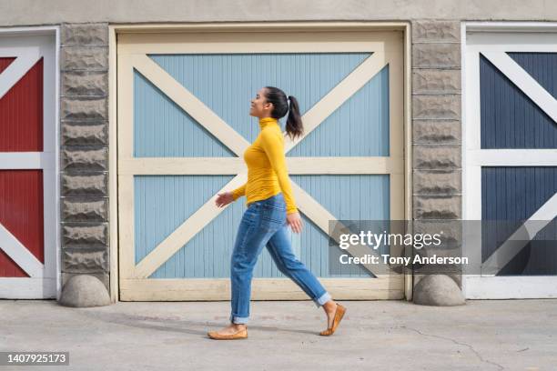 woman walking by colorful doors outside - woman walking full length stock pictures, royalty-free photos & images