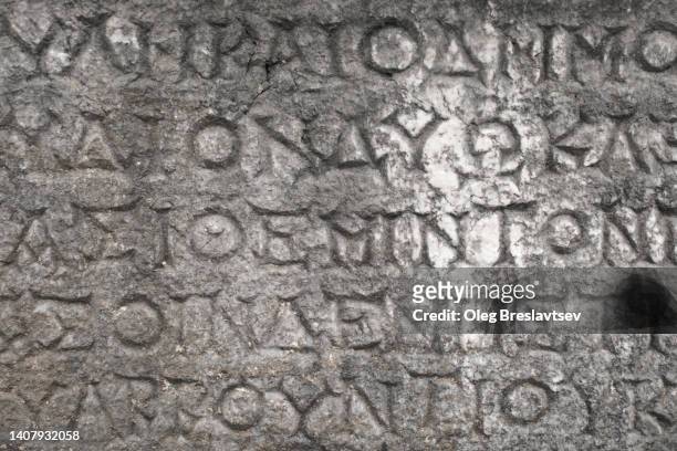 background of old antique stone wall with ancient greek or latin writing. hieroglyph system. lycian culture - ancient greek alphabet stock pictures, royalty-free photos & images