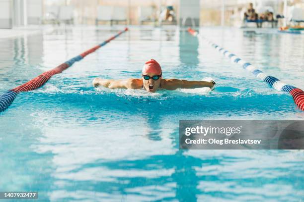 strength athletic woman swimming in breaststroke style in pool. effort, endurance and power, thirst for victory - swimming stroke stock pictures, royalty-free photos & images