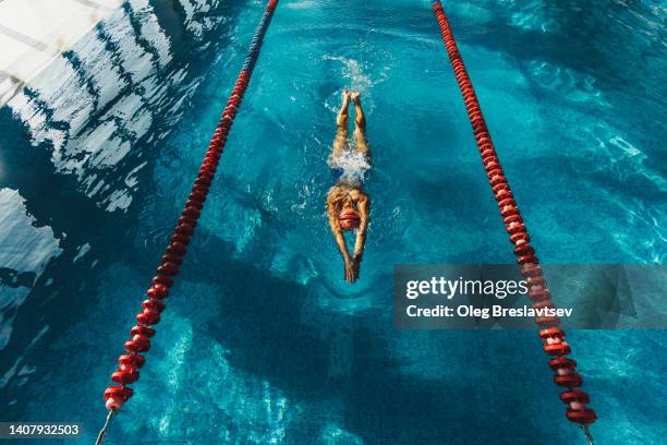 view from above of woman swimming by track in the pool. sports concept, unrecognizable person. - swim photos et images de collection