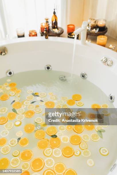 beautiful hot tub with candles, oranges and lemons. - badewanne mit obst stock-fotos und bilder