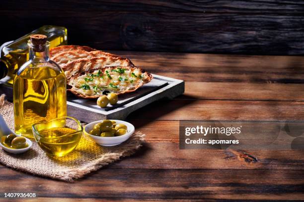 snack oder vorspeise aus knoblauchbasilikum und olivenöl bruschetta auf dem tisch in einer rustikalen küche mit kopierfläche - table aperitif stock-fotos und bilder