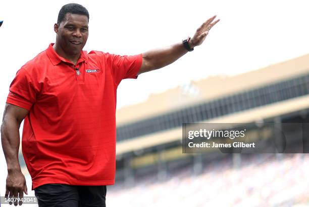 Republican candidate for US Senate Herschel Walker waves to fans as he walks onstage during pre-race ceremonies prior to the NASCAR Cup Series Quaker...