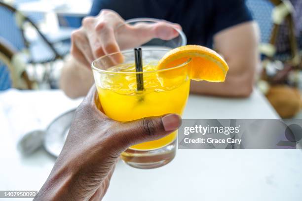 man and woman hold their drinks in a toast - holding cold drink stock pictures, royalty-free photos & images