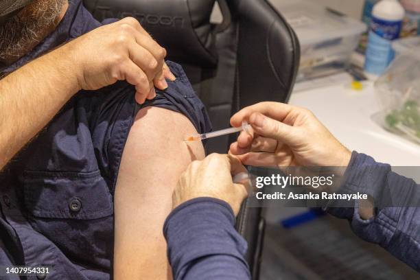 Pharmacist administers the injection of a Covid-19 vaccination booster-shot to a customer at Exhibition Pharmacy on July 11, 2022 in Melbourne,...