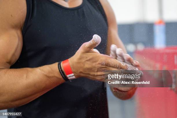 Andreas Alfaro rubs chalk on his hands at the "American Ninja Warrior" style obstacle course at the Ferox Athletics Gym on July 10, 2022 in the...