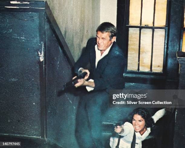 Steve McQueen , US actor, and Ali MacGraw, US actress, in a shootout in a publicity still issued for the film, 'The Getaway', USA, 1972. The crime...