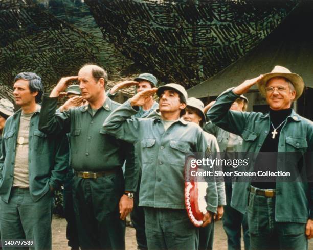 American actors Alan Alda, David Ogden Stiers, Jamie Farr, and William Christopher, saluting in a publicity still issued for the US television series...