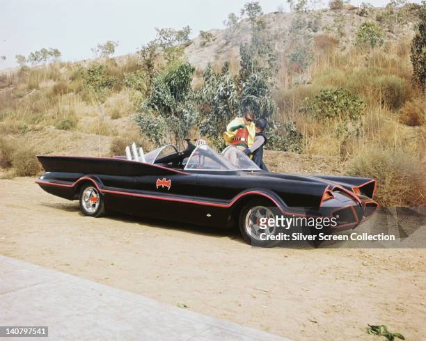 Burt Ward, US actor, and Adam West, US actor, both in costume as the 'Dynamic Duo' with the Batmobile in a publicity still issued for the television...