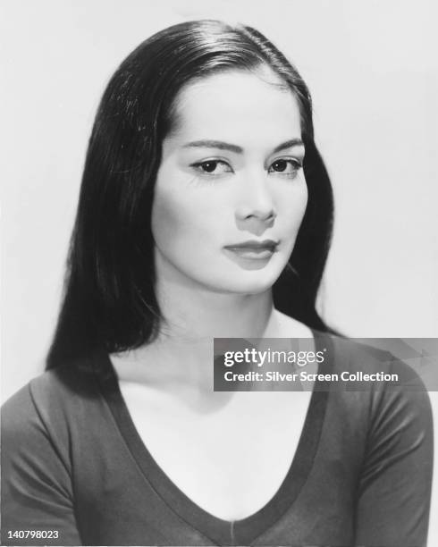 Nancy Kwan, US actress, wearing a dark-neck top, in a studio portrait, against a white background, circa 1960.