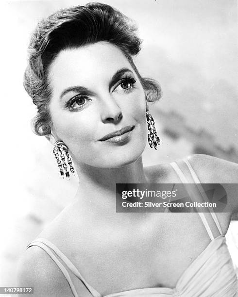 Julie London , US singer and actress, wearing a thin strap top and drop earrings in a studio portrait, against a white background, circa 1950.