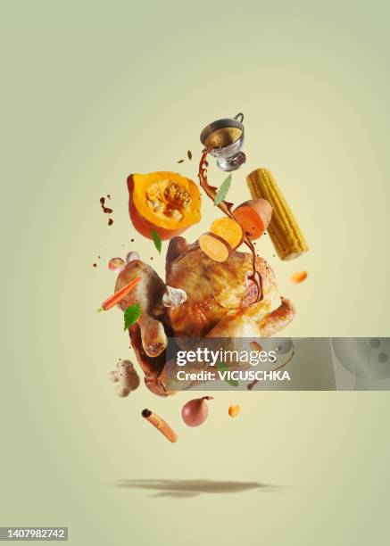 creative thanksgiving food with pouring sauce on flying roasted whole turkey, pumpkin, sweet potato, corn and carrots flying in the air - thanksgiving food stock pictures, royalty-free photos & images