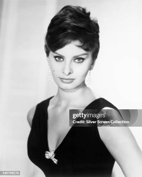 Sophia Loren, Italian actress, wearing a sleeveless top, with a plunging neckline, in a studio portrait, against a white background, circa 1955.