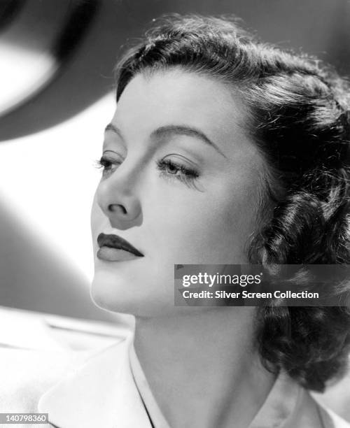 Headshot of Myrna Loy , US actress, in profile, looking toward the left of the image, in a studio portrait, circa 1935.