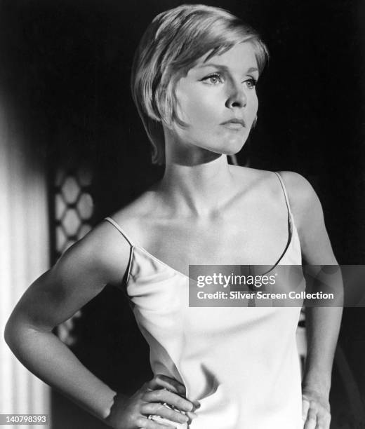 Carol Lynley, US actress, wearing a white thin strap top, posing with her hands on her hips in a studio portrait, circa 1965.