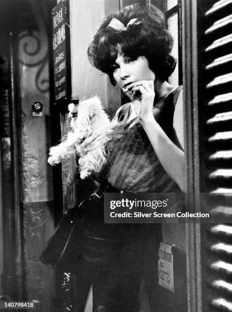 Shirley MacLaine, US actress, smoking a cigarette and posing in a doorway in a publicity still issued for the film, 'Irma La Douce', 1963. The...