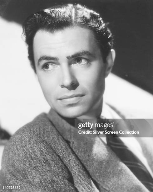 James Mason , British actor, wearing a tweed jacket over a white shirt with a dark striped tie, in a studio portrait, circa 1940.