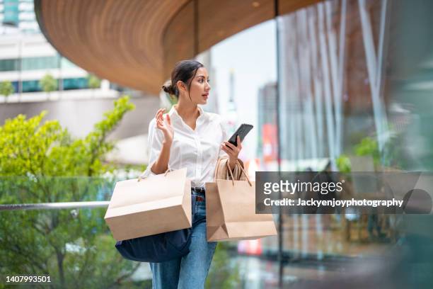portrait of a wealthy asian woman outside a luxury mall - boodschappen doen stockfoto's en -beelden