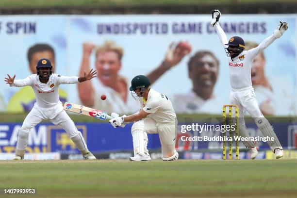 Oshada Fernando, left, and Niroshan Dickwella of Sri Lanka appeal successfully for the wicket of David Warner of Australia during day four of the...