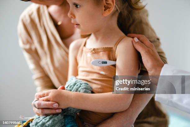 portrait of an anonymous girl getting her temperature checked at the doctorâs office - digital thermometer stock pictures, royalty-free photos & images