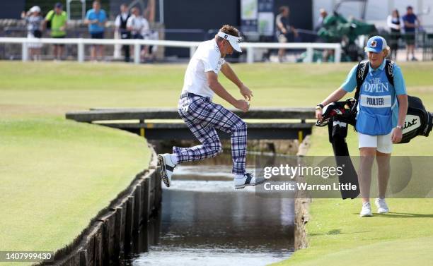 Ian Poulter of England jumps the water hazard on the 1st during a practice round prior to The 150th Open at St Andrews Old Course on July 11, 2022 in...