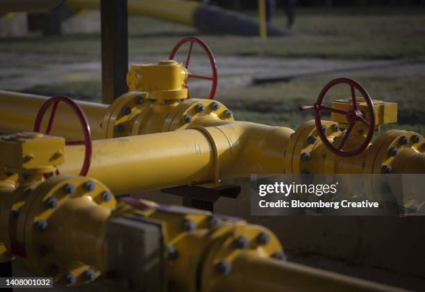 pipework and valve wheels at a gas storage facility - natural gas photos et images de collection