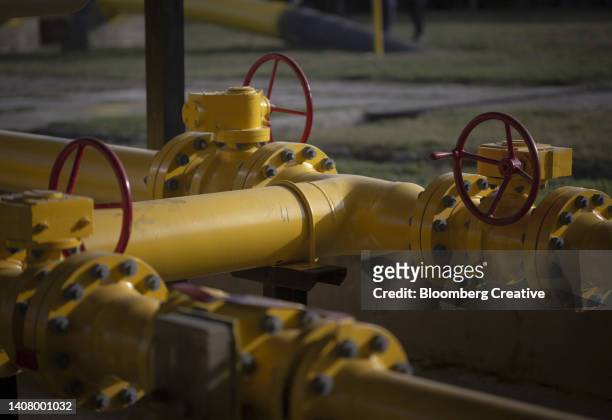 pipework and valve wheels at a gas storage facility - aardgas stockfoto's en -beelden