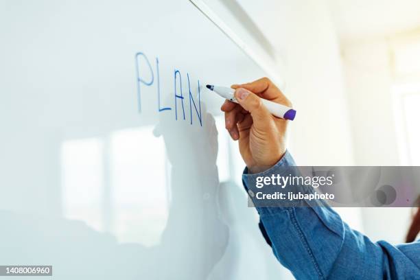 businessman writing drawing his ideas financial solutions on whiteboard - presentatieborden stockfoto's en -beelden