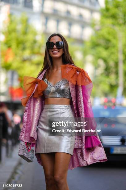 Marta Sierra wears black square sunglasses, a silver shiny sequined with embroidered pearls V-neck / cropped tank-top, a pink tulle with embroidered...