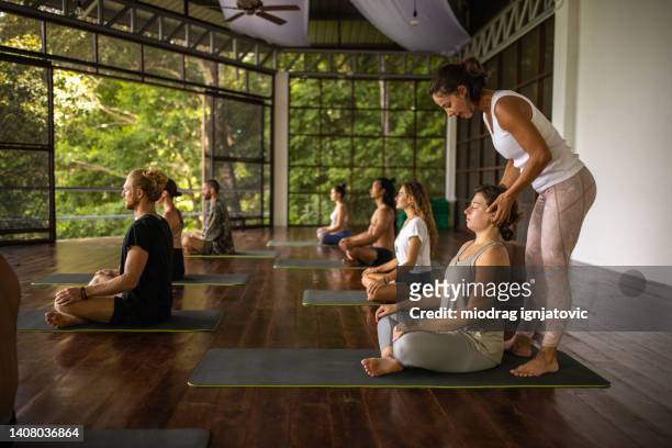 female yoga teacher leading an yoga class - professor de ioga imagens e fotografias de stock