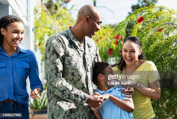veterano afroamericano de la marina caminando con su familia, riendo - us navy fotografías e imágenes de stock