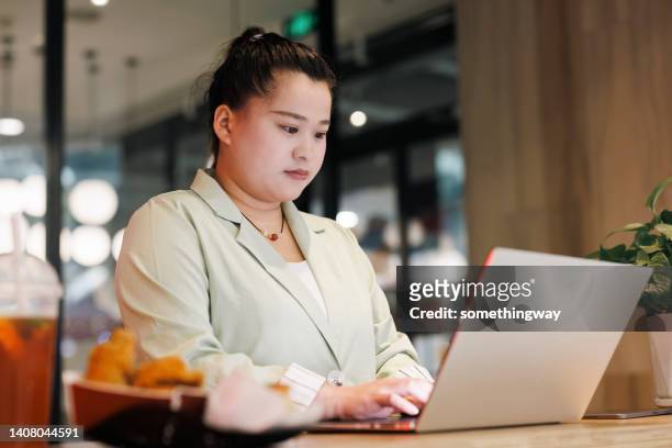 asian women work hard with laptops in restaurants - fat asian woman 個照片及圖片檔