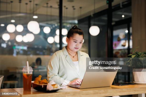 overweight women working on laptops in restaurants - fat asian woman 個照片及圖片檔