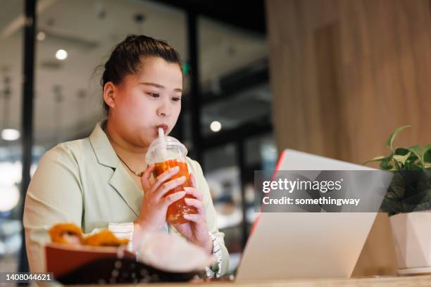 overweight women drink juice in restaurants and work on laptops - fat asian woman 個照片及圖片檔