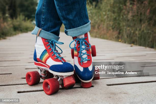 best ager women having fun outdoors with vintage roller skates and bubbles - rolschaatsen schaats stockfoto's en -beelden