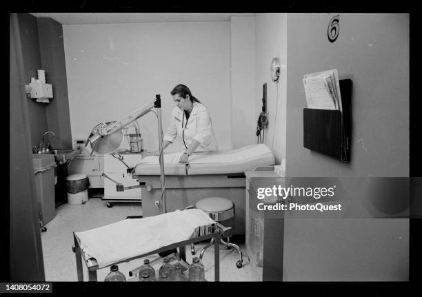 An unidentified health care professional replaces the paper on a treatment table in an exam room at an unspecified abortion clinic, Washington DC,...