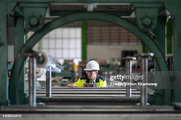 male engineer and tablet working at manufacturing factory. - factory workers stockfoto's en -beelden