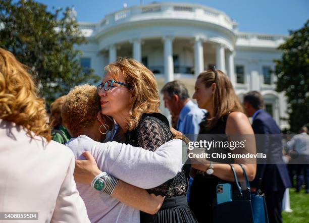 Gabby Giffords, former U.S. Representative and mass shooting survivor, hugs an audience member during an event to celebrate the Bipartisan Safer...