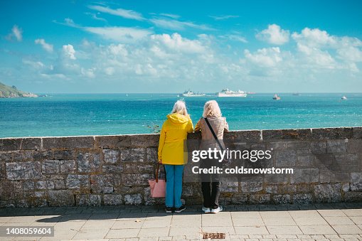Rear view of two senior women looking at sea and harbour Rear view of two senior women looking at sea and harbour