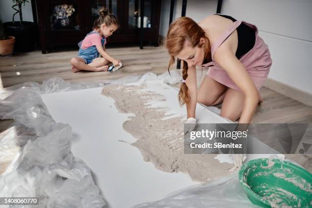 woman making an abstract painting with plaster - relief carving stock-fotos und bilder