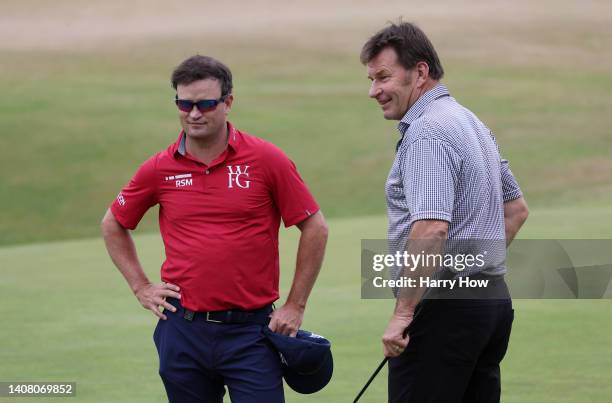 Sir Nick Faldo of England talks to Zack Johnson of The United States on the 18th during the Celebration of Champions Challenge during a practice...