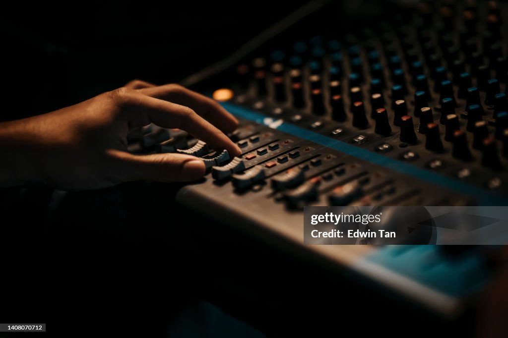 Asian sports event crew working at backstage with control panel on stage lighting , sound system and lighting effect