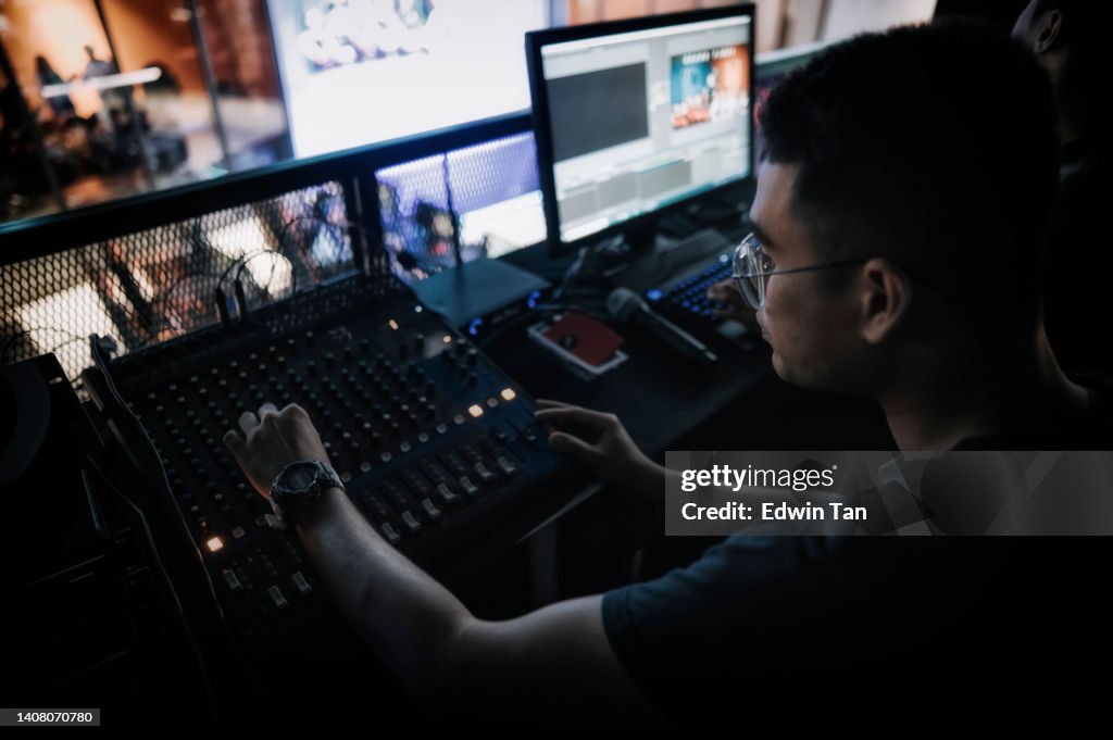 Asian sports event crew working at backstage with control panel on stage lighting , sound system and lighting effect