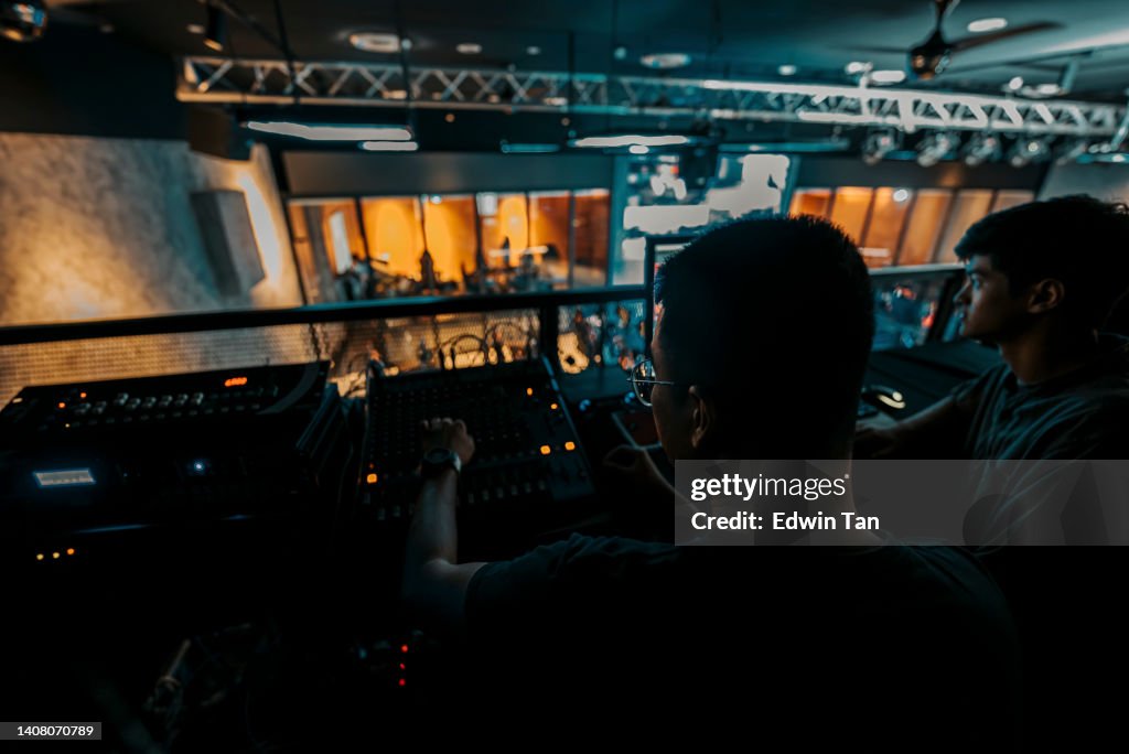 Equipe de eventos asiáticos de esports trabalhando nos bastidores com painel de controle na iluminação do palco, sistema de som e efeito de iluminação
